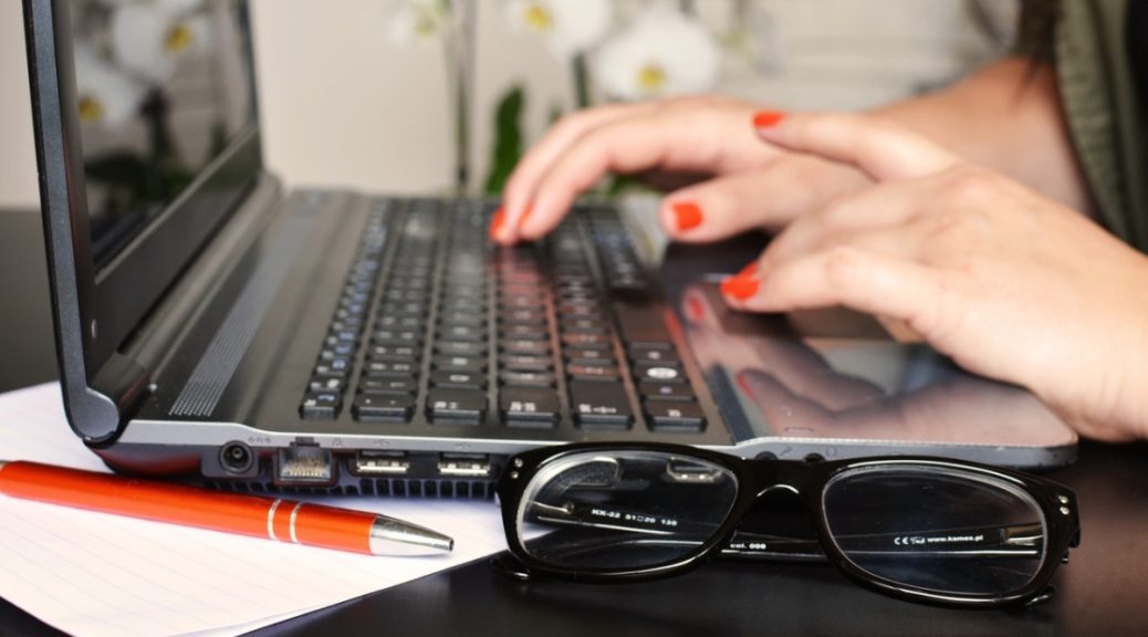 person typing on laptop glasses